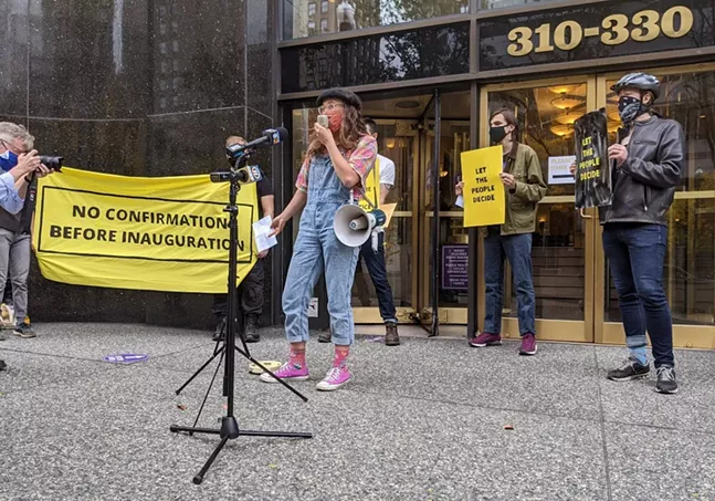 Elise Silvestri of Sunrise Pittsburgh uses a megaphone during a protest outside of the Grant Building in Downtown Pittsburgh - CP PHOTO: AMANDA WALTZ