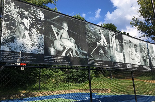 Teenie Harris photos displayed along the fence by the park's half basketball court - PHOTO COURTESY OF SCOTT ROLLER/PITTSBURGH PARKS CONSERVANCY
