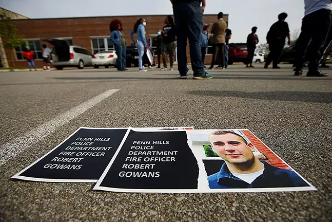 Posters calling for the firing of officer Robert Gowans sit on the ground at a rally and press conference - CP PHOTO: JARED WICKERHAM