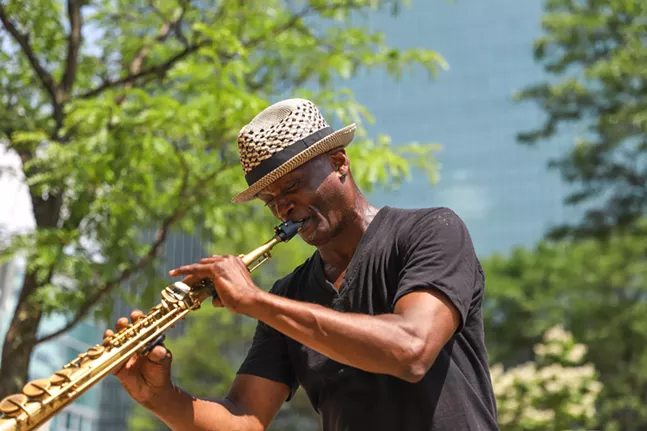 Daryl Leeper plays the saxophone for festival goers outside of Point State Park. - CP PHOTO: KAYCEE ORWIG