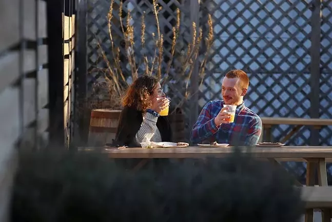 Natalie Isenberg and Connor Brem drink beers outside of East End Brewing Company. - CP PHOTO: JARED WICKERHAM