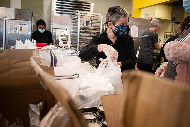 A volunteer packages orders during Fish Fry Friday at Community Kitchen Pittsburgh in Hazelwood. - CP PHOTO: PAM SMITH