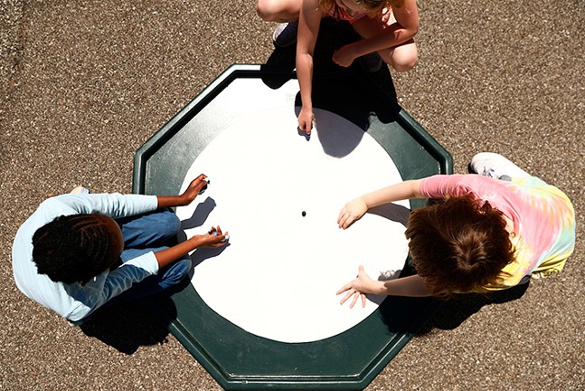 Anna Marie LaGamba and Dan LaGamba teach children to play marble at Phillips Elementary School in the South Side on Wednesday, May 11th.  - CP PHOTOS: JARED WICKERHAM