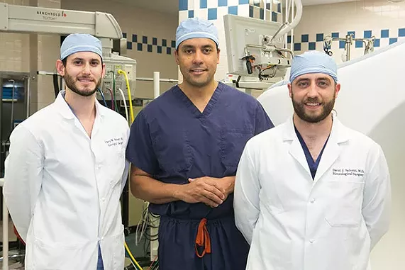 UPMC neurosurgeon David Okonkwo, center, with his current residents Gregory Weiner (left) and David Salvetti - CP PHOTO BY JOHN COLOMBO