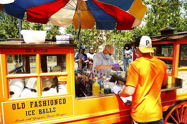 Gus Kalaris, owner of Gus & Yiayia’s food cart, serves up old-fashioned shaved ice balls with employee Matt Szymanowski in the North Side. - CP PHOTO: JARED WICKERHAM