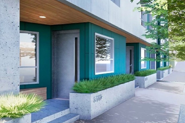 An image of the front of a boxy, modernist house with a turquoise exterior and a white door