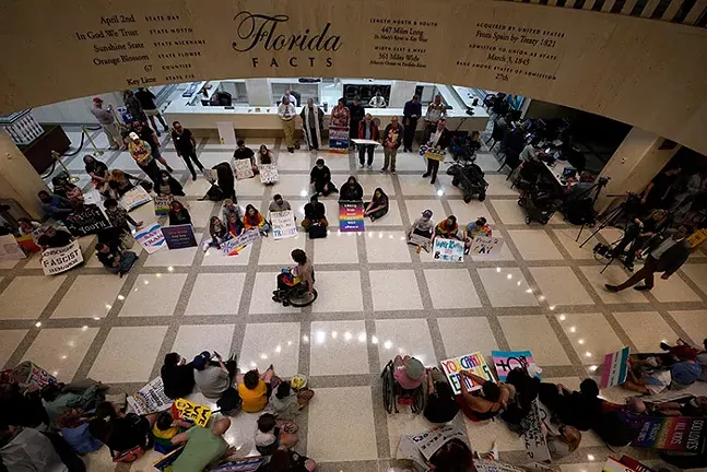 A group of demonstrators spread out all over a tiled floor