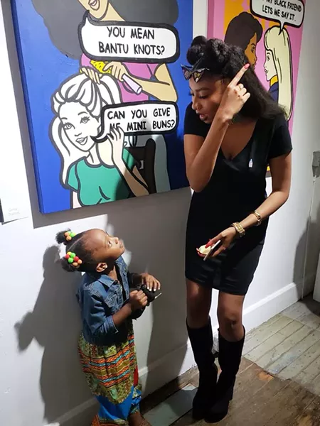 Kamara Townes, aka Wavy Wednesday, talks with her niece in front of her Barbie-inspired artwork.