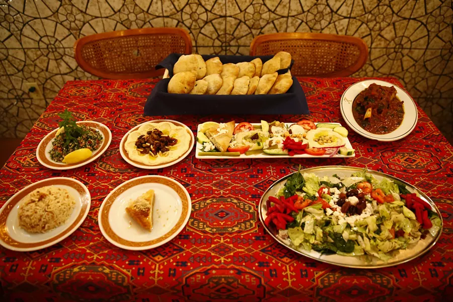 Various dishes including homemade artisan Syrian bread, Tabolli, hummus bi lahme, mazza, mowzat lamb shank, rice, Khalil's signature salad, and desserts - CP PHOTO: JARED WICKERHAM