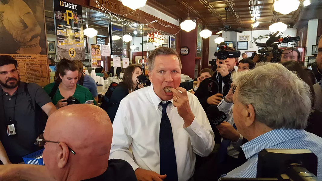 Gov. John Kasich finishes his fish sandwich, surrounded by reporters at the Oyster House - PHOTO BY REBECCA NUTTALL