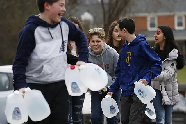 Shadyside Academy eighth grader Parker Mendham, 13, helps his classmates load up water into a car during a 412 Food Rescue - CP PHOTO: JARED WICKERHAM