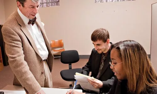 University of Pittsburgh law students Jonathan Payne and Brittney Pepper discuss legal matters with professor Harry Gruener during a recent law clinic. - BRIAK KALDORF