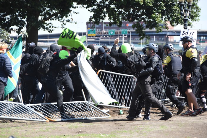 Police grab a guy, who hands the sign over to his friend