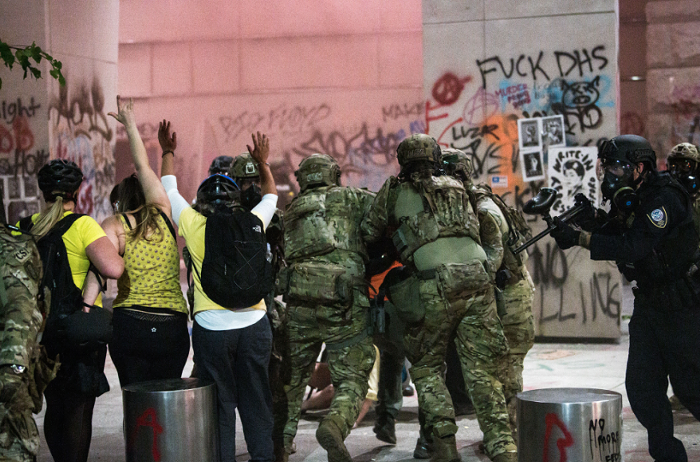 DHS officers arrest a member of the Wall of Moms protest group on July 20. DHS officers arrest a member of the Wall of Moms protest group on July 20.