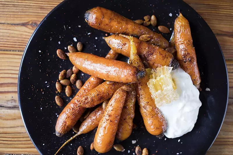 Rainbow carrots are served with with local honeycomb, whipped goat cheese and smoky pepitas. - MABEL SUEN