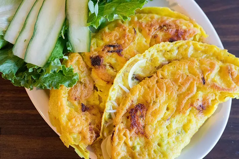 Banh xeo are Vietnamese-style crispy crepes filled with shrimp, pork, and bean sprouts, served with fish sauce. - MABEL SUEN