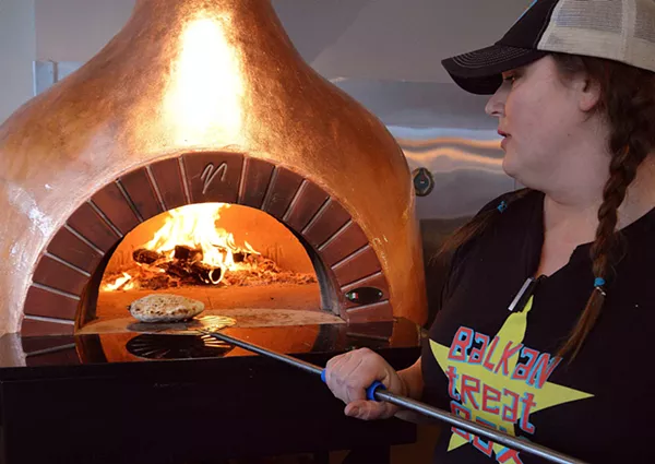 Loryn Nalic bakes bread over a wood fire. - TOM HELLAUER