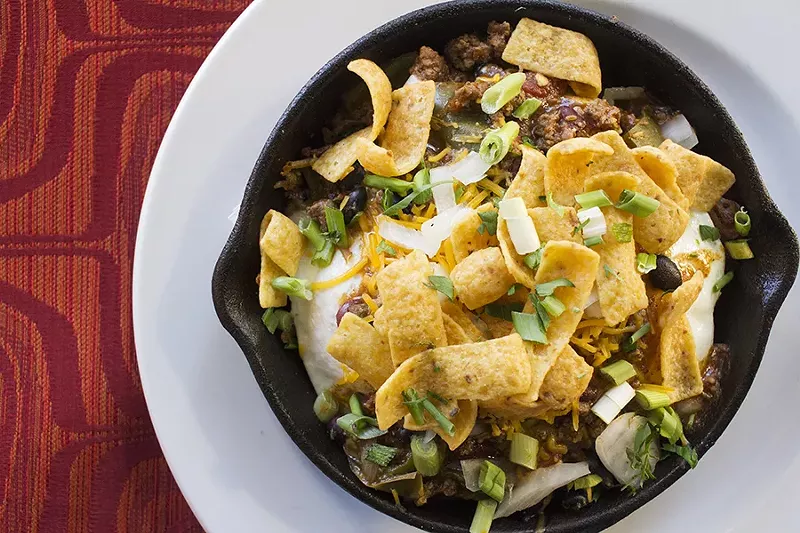 The "Stage Left Slinger" includes hash browns, a four-ounce burger patty, chili, a fried egg, cheddar, Fritos and scallions. - PHOTO BY MABEL SUEN