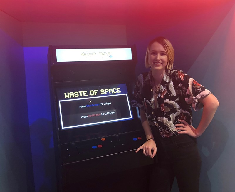 Webster U. graduate Tamsen Reed, next to a game she co-produced for the St. Louis Science Center. - COURTESY OF TAMSEN REED