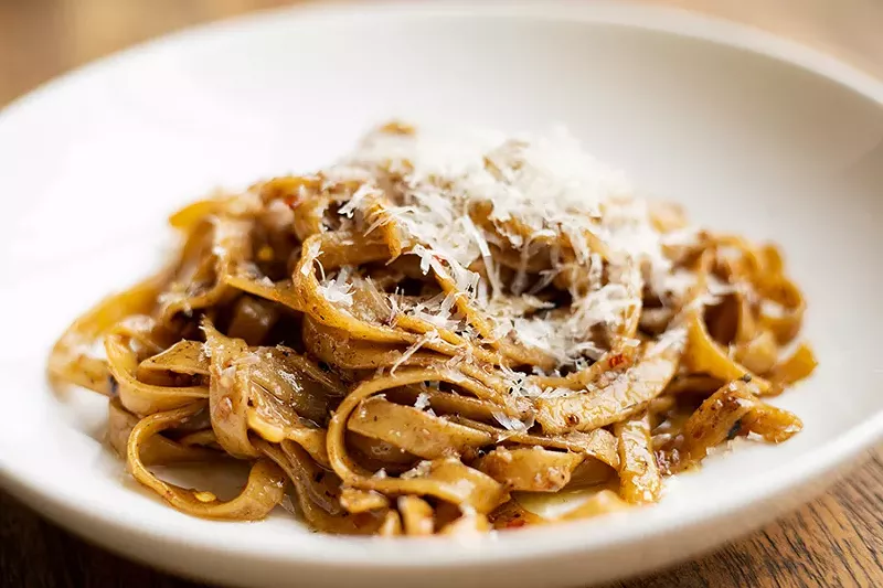 The Grown Up Garlic Noodles combine housemade tagliatelle pasta, olive oil, fermented black garlic, chile flakes and Parmesan. - MABEL SUEN