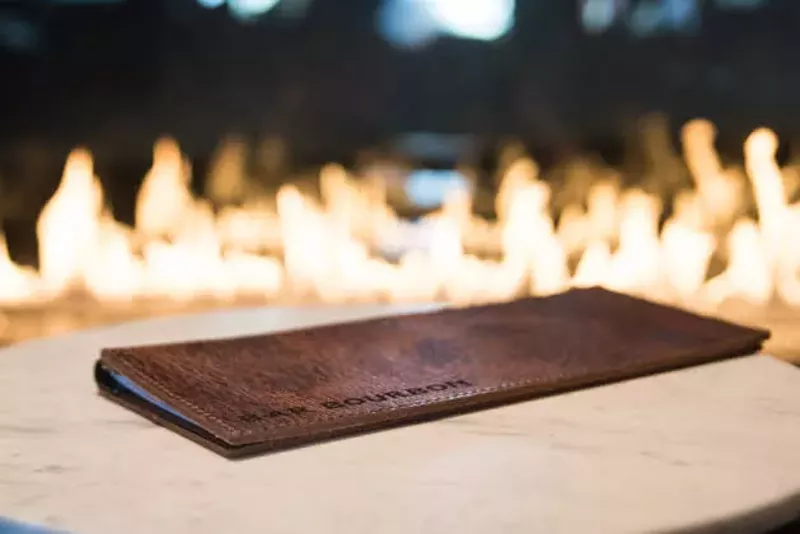 Bar Bourbon features a gorgeous fireplace. - TRENTON ALMGREN-DAVIS