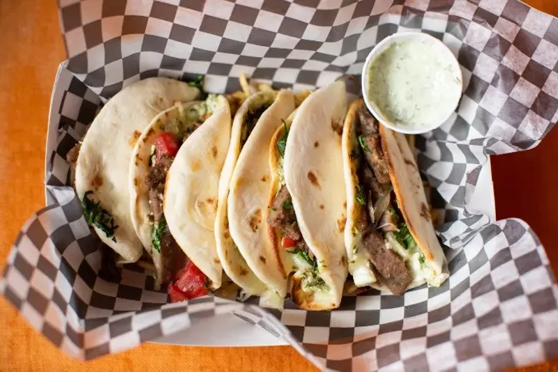 Gyro tacos, with mini flour tortillas stuffed with gyro meat, red onion, spinach, tomato and feta, served on a bed of potato sticks with a side of tzatziki. - MABEL SUEN