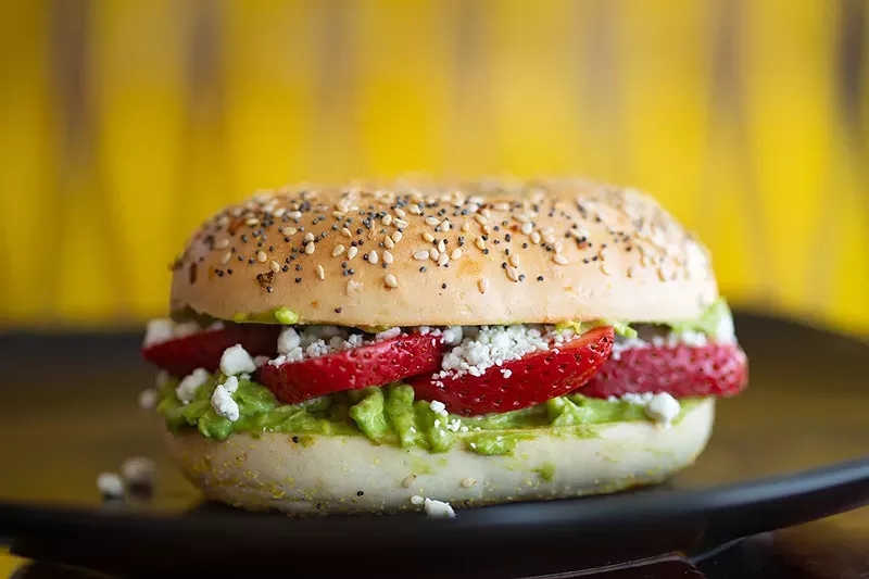 Avogoa bagel with avocado spread, goat cheese and strawberries on a toasted everything bagel. - MABEL SUEN
