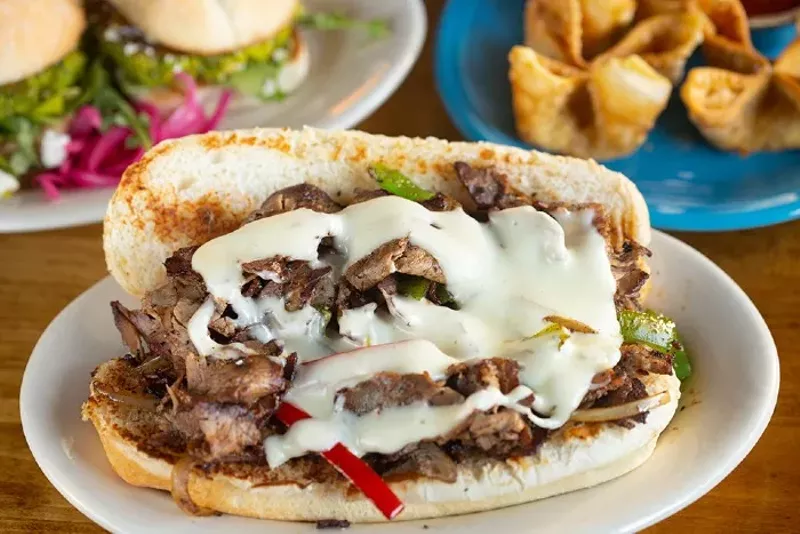 The Philly features smoked, shaved strip loin topped with a housemade cheese whiz, mixed peppers and onions on a hoagie. - MABEL SUEN