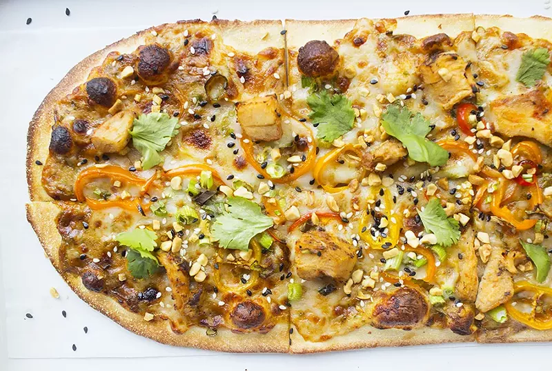 The "Thai Dye" features spicy peanut sauce, mozzarella, sweet pepper, chicken, peanuts, sesame mix, garlic and cilantro. - PHOTO BY MABEL SUEN