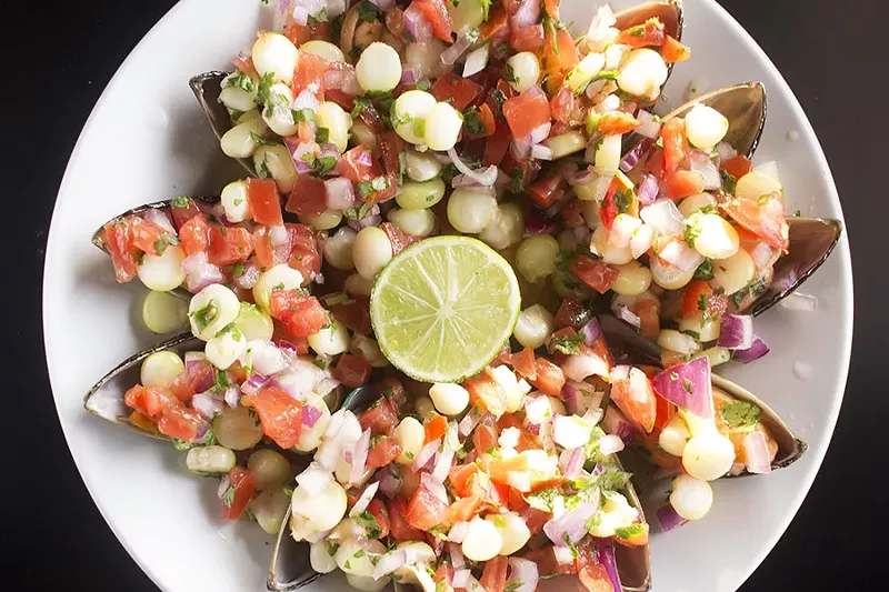 Choros a la chalaca is a traditional recipe of steamed mussels, topped with diced red onion, tomato, corn and cilantro. - MABEL SUEN