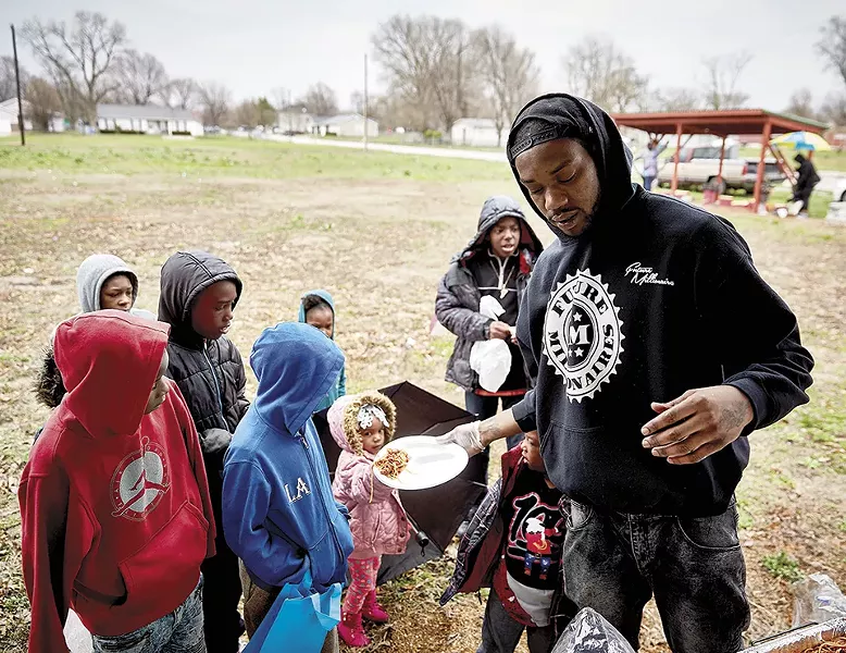 Liddell serves lunch to children at an Easter event. "He is at his best when engaging with young people," says SLU's Oberle. - THEO WELLING