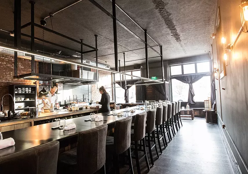 Diners sit around an open kitchen, with the chef at the center. - MABEL SUEN