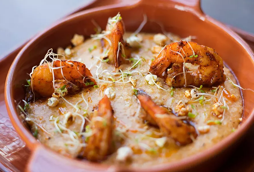 Prime 55’s Cajun influence is most apparent in its shrimp and grits, served with blackened shrimp, popcorn grits and chile oil. - MABEL SUEN