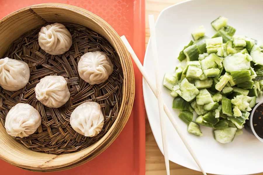 Pork soup dumplings are paired here with a side of cucumber with garlic sauce. - MABEL SUEN