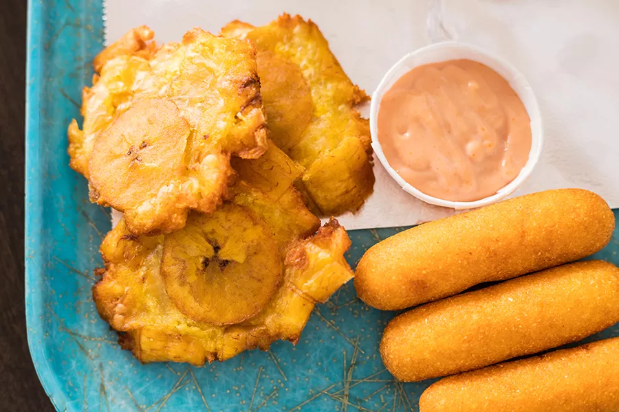 Tostones (green plantains) and sorullitos de maiz (deep-fried cornmeal fritters). - MABEL SUEN