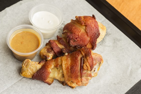 "Bacon Legs," chicken drumsticks wrapped in bacon, with blue cheese and peanut sauces. | Mabel Suen