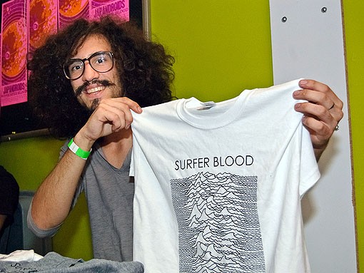 Surfer Blood member Marcos Marchesani shows off some of his band's merch. See more photos from last night's show in our slideshow. - PHOTO: JASON STOFF