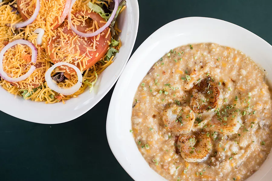Shrimp and cheesy grits, shown here with a chef’s salad, demonstrate Hourd-Bryant’s skill at Southern cooking. - MABEL SUEN