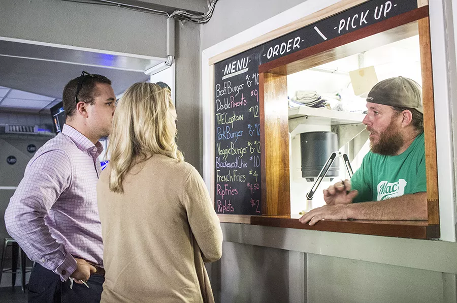 Customers order at a small window in the rear of the bar. - PHOTO BY MABEL SUEN