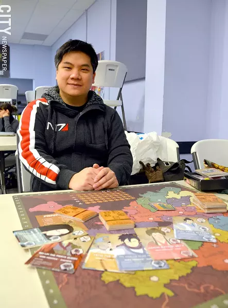 Game creator Nicholas Yu with his newest game, Eternal Dynasty. - PHOTO BY MATT DETURCK