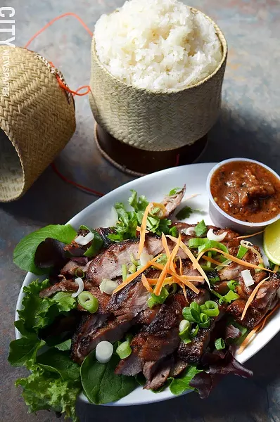 Marinated grilled pork with hot sauce and sticky rice. - PHOTO BY MATT DETURCK