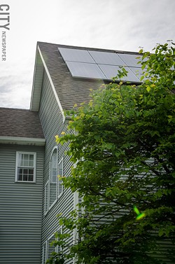 The solar panels on Cynette Cavaliere's Penfield home provide enough electricity to offset the power she uses to charge her Chevy Volt. - PHOTO BY MARK CHAMBERLIN