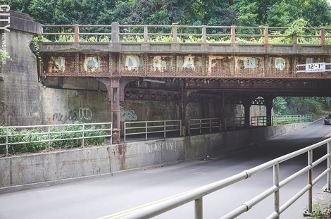 Graffiti created by a group of friends in 1981 to protest the reinstatement of draft registration has remained on the CSX bridge that passes above Penfield Road in Brighton. - PHOTO BY MARK CHAMBERLAIN