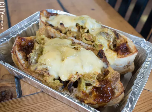 The Tom Boy sandwich includes grilled spiedies, homemade tomato jam, fried jalapeños, and Gouda. - PHOTO BY JACOB WALSH