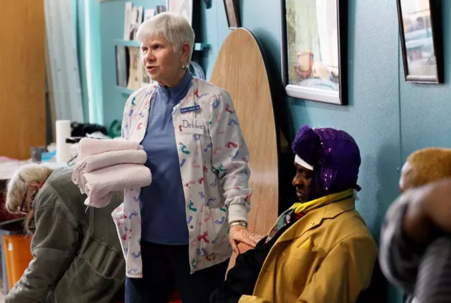 Debbie Sigrist, the founder of the St. Joseph's House of Hospitality foot clinic, with a guest. - PHOTO BY MAX SCHULTE