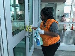 A worker disinfects the doors and handles at the Rochester Transit Center. - PHOTO BY DAVID ANDREATTA