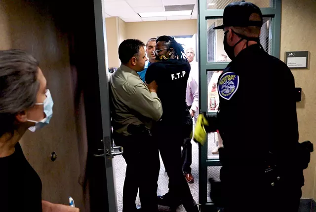 A Rochester Police Department officer draws his Taser on Free the People Roc organizer Stanley Martin, though he did not fire it. - PHOTO BY MAX SCHULTE