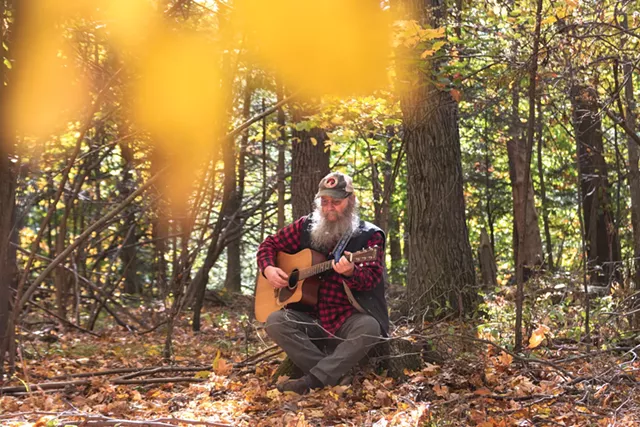 Bob Bunce plays the guitar on his rural property near Groveland, New York. - PHOTO BY RYAN WILLIAMSON