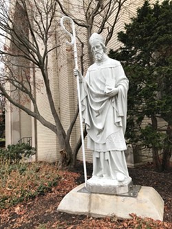 The statue of St. Boniface, outside of St. Boniface Catholic Church in the South Wedge, with its new staff dedicated to Margaret Nordbye, who was remembered as a shepherd of the neighborhood. - PHOTO BY DAVID ANDREATTA