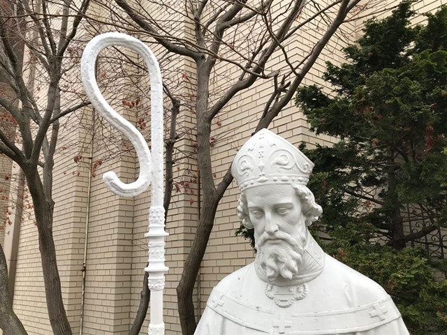 The statue of St. Boniface outside the namesake Catholic church in the South Wedge has a new staff dedicated to Margaret Nordbye, who was called 'a shepherd of the neighborhood.' - PHOTO BY DAVID ANDREATTA